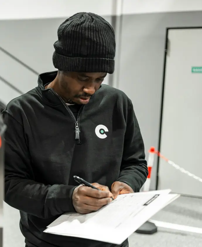 A man is writing by a car.